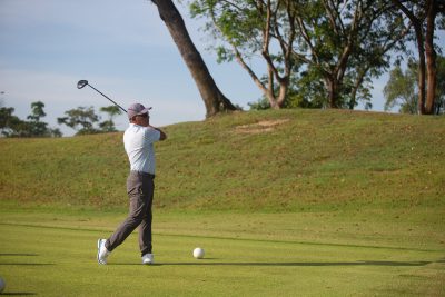 Golfer finishing a tee shot at Johor Golf & Country Club