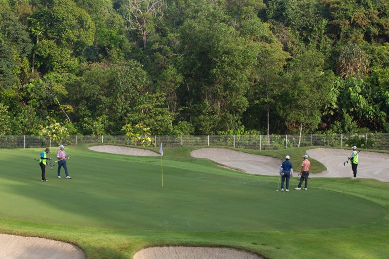Golfers and caddies on a green